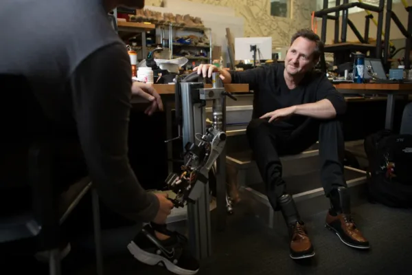 Man examining bionic leg in lab setting