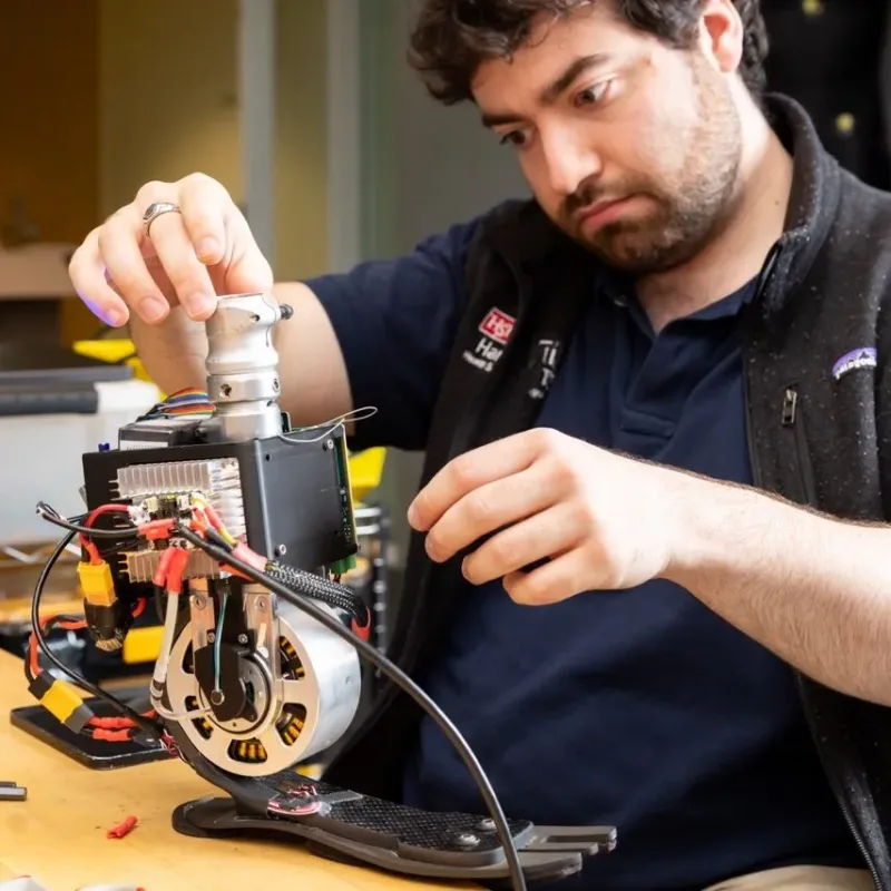 Researcher examining bionic leg attachment on top of a desk