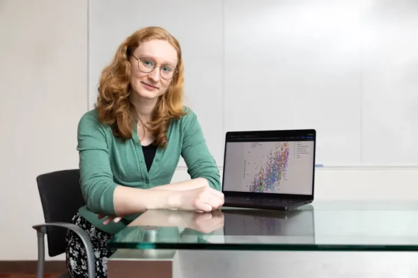woman sitting at table with laptop showing computational image